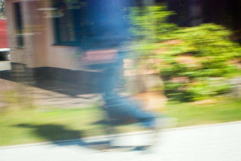 Ein unscharfes Bild eines Radfahrers in Bewegung, das metaphorisch die beruhigende Wirkung von CBD Öl auf die Psyche darstellt, indem es die hektische Bewegung des Lebens in einen Zustand der Ruhe überführt.